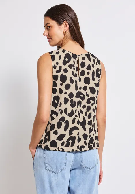 Frau von hinten mit ärmellosem Leopardenmuster-Top und Jeans.